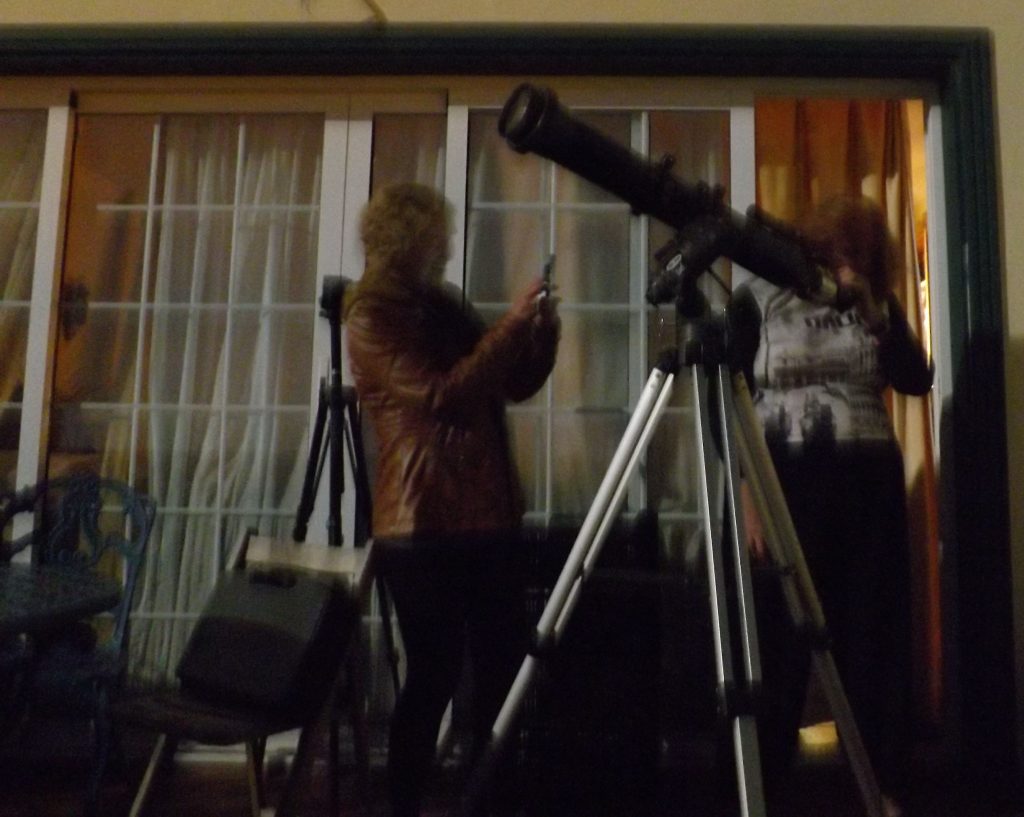 10 cm telescope on a tripod with two people